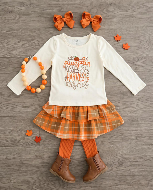 Girl Pumpkin Kisses plaid skirt set for Thanksgiving, laid out with bows and boots